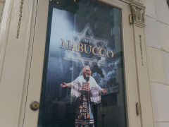 A poster at the benedum center of an old man draped in white with clouds and the star of david behind him.