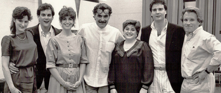 An old picture of three women and four men posing for a group picture 