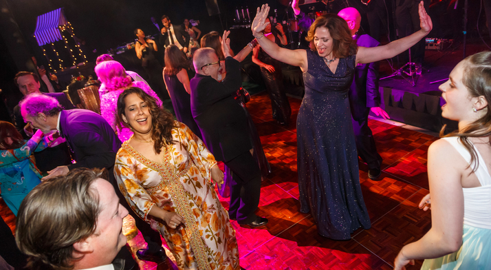 Well-dressed men and women of different ages dance